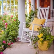 bright blooms in a flower bed and a pot and a colorful pillow on the chair for a bold spring feel