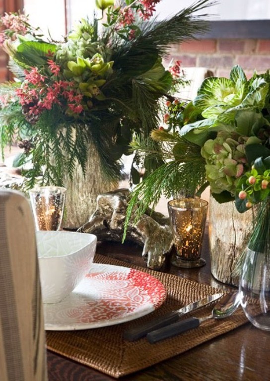 a vintage-inspired Christmas tablescape with woven placemats, printed red and white porcelain, lush greenery and florals, mercury glass candleholders