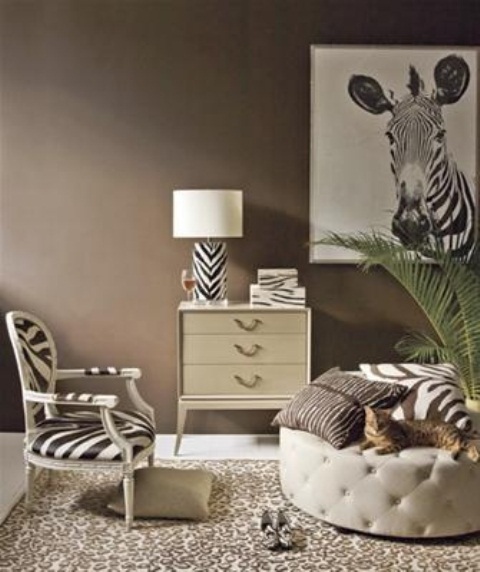 a tropical-inspired space with brown walls, a leopard print rug, a zebra print chair and a lamp, zebra print pillows and a zebra print on the wall
