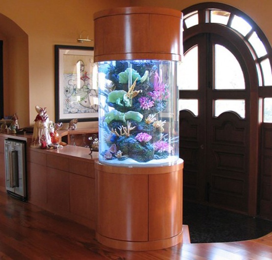 a round aquarium enclosed into rich-stained wood makes a lovely decor feature and separates the entryway from the rest of the house