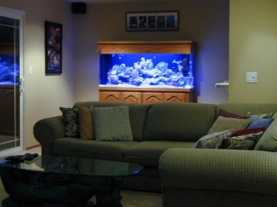 a living room with an aquarium in the corner, the piece adds chic and interest to the space