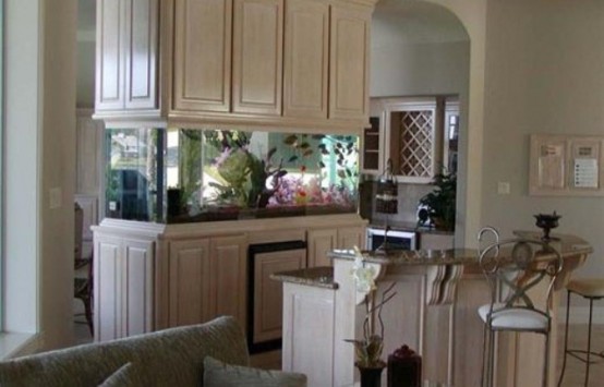 an aquarium clad with whitewashed panels in front of a breakfast bar to enjoy the look while eating