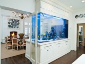 a large aquarium clad with white panels divides the dining and living room and adds to the decor of both spaces