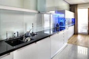 a minimalist white kitchen with black countertops and a large aquarium decorated in a similar way is a very lovely idea