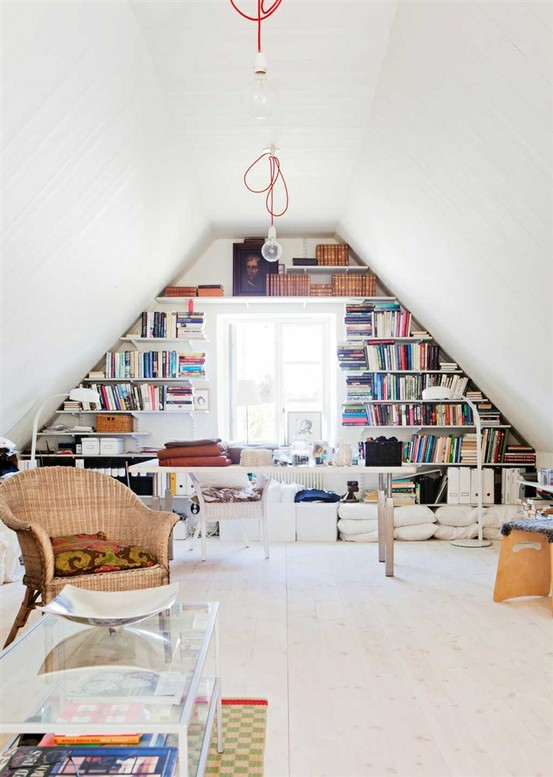 a stylish eclectic home office with built-in shelves, a desk, pillows, chairs, a bech and a glass coffee table plus cool ceiling and floor lamps