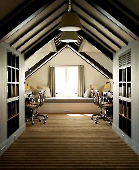 a cool shared attic home office with dark wooden beams on the ceiling, desks and leather chairs, a daybed at the window and large bookcases for storage