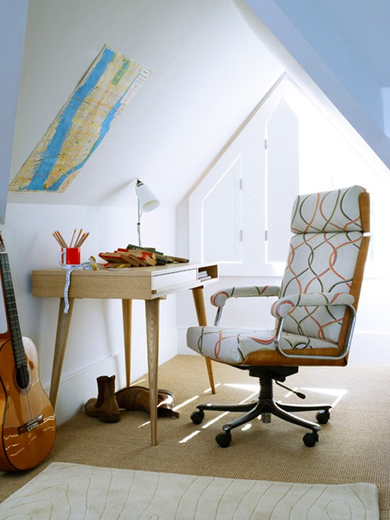 a tiny attic home office with a window shutters, a stained desk, a printed chair, a map on the wall and some rugs