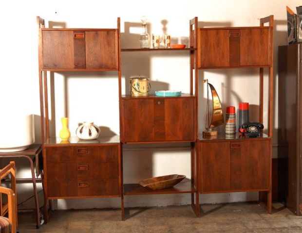 a rich stained wooden wall unit with cabinet compartments and open shelves placed with a check pattern