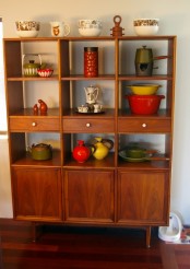 a rich stained storage unit with closed compartments, drawers and open shelves is a timeless piece to use