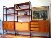 a large and chic storage unit with closed compartments, sliding doors, drawers and open shelves