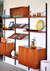 a mid-century modern wall unit with open shelves, cabinets and slanted shelves of a rich stain color