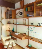 an oversized wooden wall unit with shelves, open box shelves, drawers and a mini floating desk integrated