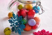 a jar with mini colorful Christmas ornaments and bells plus colorful snowflakes for festive decor