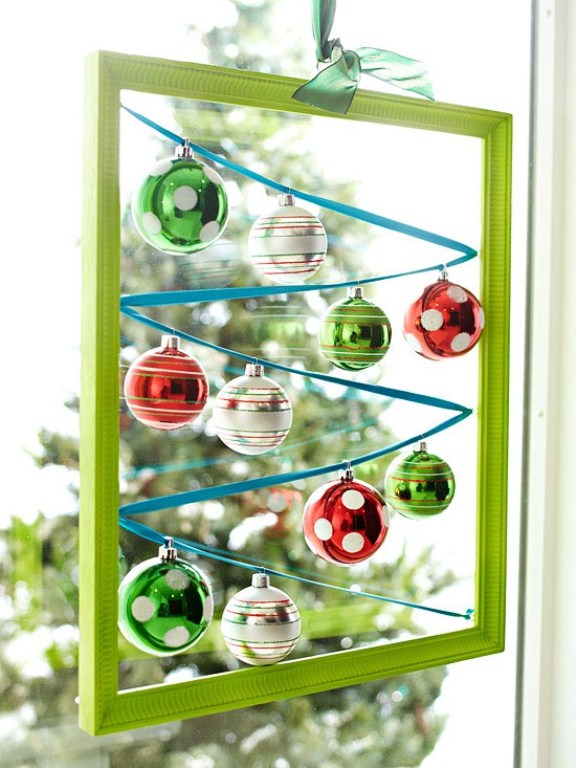 a green frame with colorful Christmas ornaments hanging inside is a cool and creative Christmas decorations