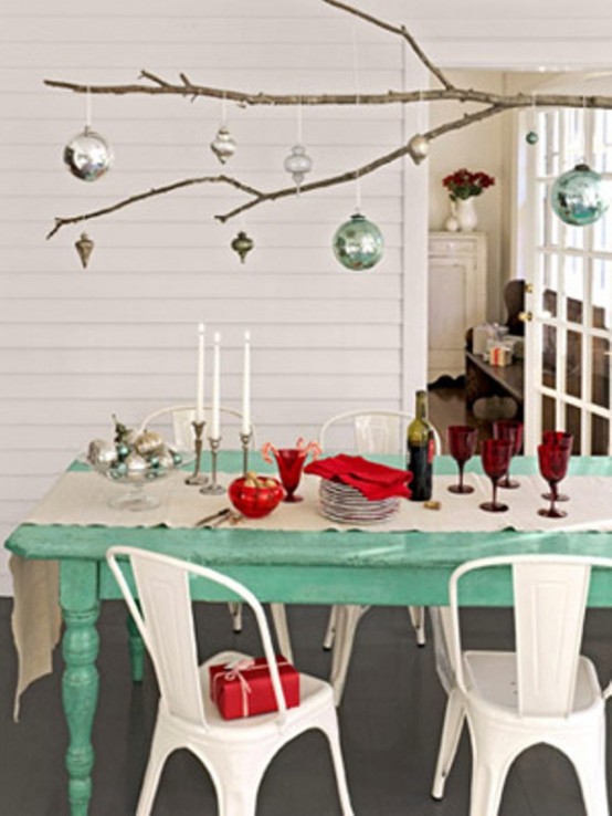 a branch with some Christmas ornaments hanging down is a cool overhead decoration for a holiday or festive space