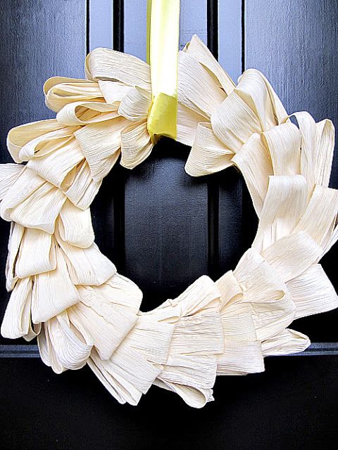 an elegant and laconic bent corn husk wreath with a yellow ribbon is a stylish and rustic yet modern decor idea for outdoors