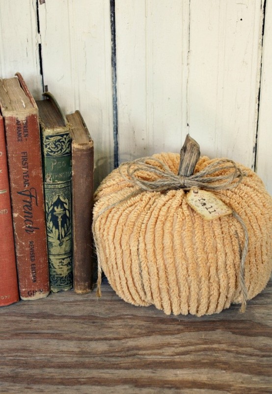 a muted color fabric pumpkin with wooden stems and twine is a stylish shabby chic decoration for the fall