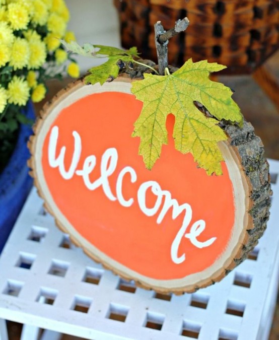 a wood slice in orange, with a stem and a real leaf is a lovely fall decoration with a strong rustic touch