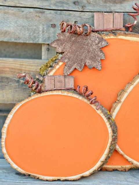an arrangement of orange wood slices, twine and plywood leaves is a cool idea for indoor or outdoor decor