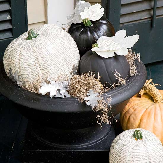 a black urn with a newspaper decoupage pumpkin, black pumpkins, hay, newspaper and fabric leaves
