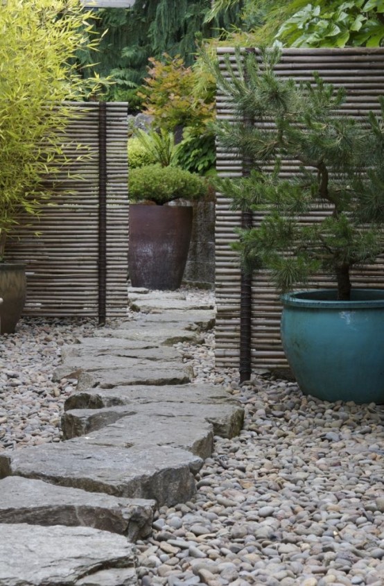 pebbles and a large rough stone path on top match potted plants and screens