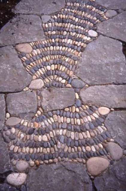a stone and pebble garden path with pebbles forming some patterns looks cool and bold