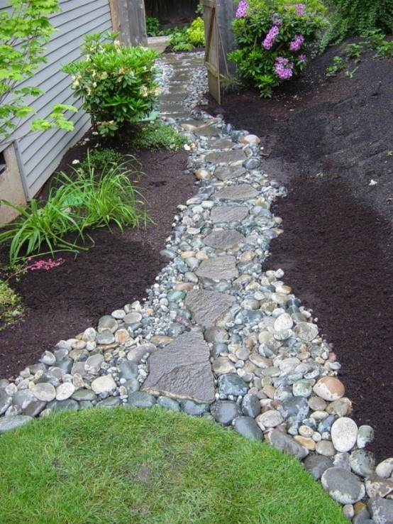 a pebble and rock garden path like this one will add a natural feel to the garden and make it bolder