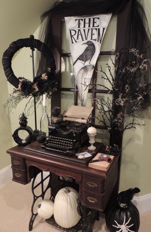 vintage Halloween decor with a console table, a vintage window frame, a tyepwriter, faux blooms, branches and a black wreath plus some white pumpkins
