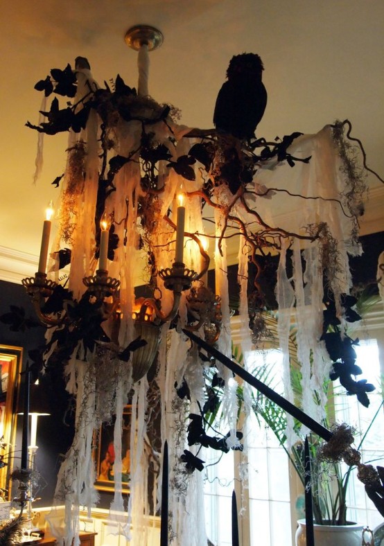 a chandelier with spiderwebs, branches, faux blooms, blackbirds and black branches is a gorgeous idea for Halloween decor