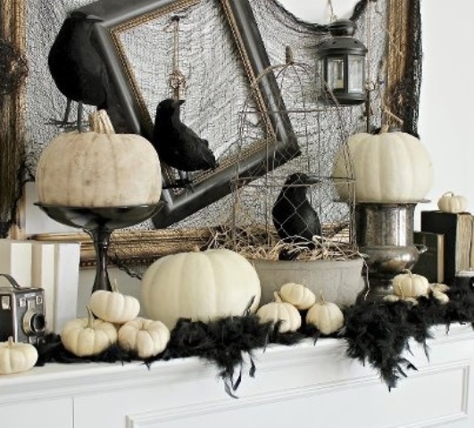 a stylish Halloween mantel decorated with black feathers, white pumpkins, blackbirds, cages and empty frames is a great idea