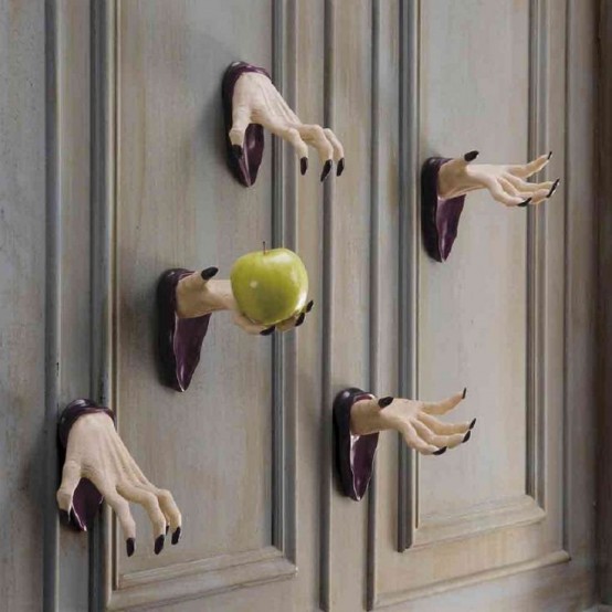 witches' hands attached to the wall and with a green apple are great Halloween decor idea, easy to realize