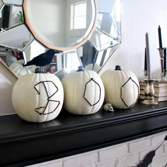 white pumpkins with black yarn stitching right on them, with letters are a unique solution for Halloween decor