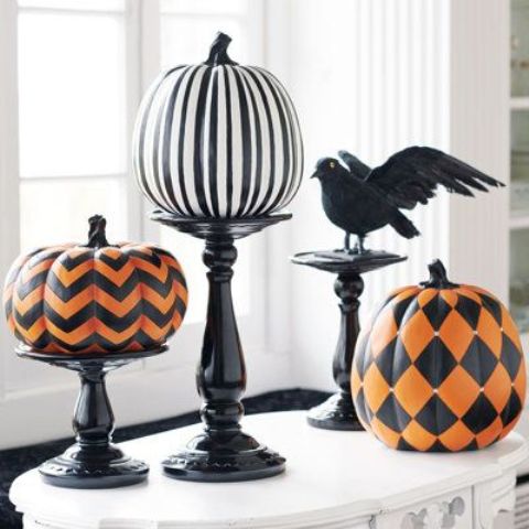 a Halloween decoration of black stands, a striped black and white pumpkin, chevron and diamond print pumpkins and a blackbird is a fun and cool idea