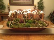 a dough bowl with moss, vine balls, antlers and spring bulbs for a winter decoration or centerpiece