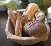 a dough bowl with fresh bread is an edible centerpiece idea -what can be more natural than storing bread in a dough bowl