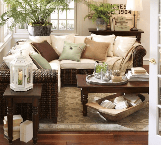 an antique dough bowl used for storing books under the table - save the tabletop space