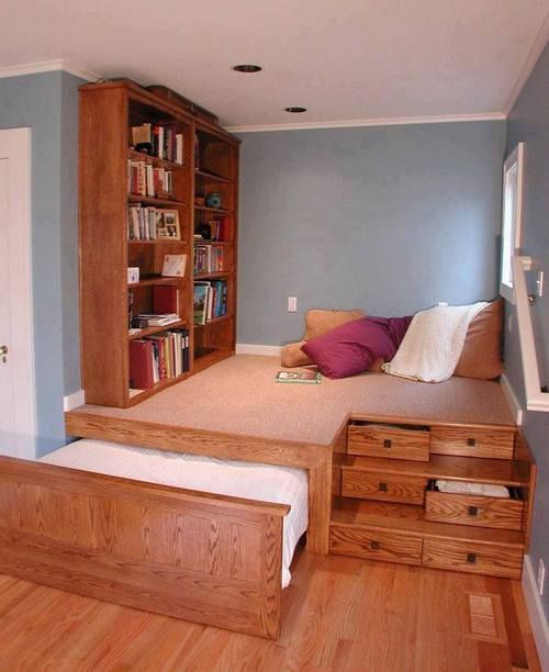 a high platform saving space features a reading nook, some drawers for storage and a retractable bed