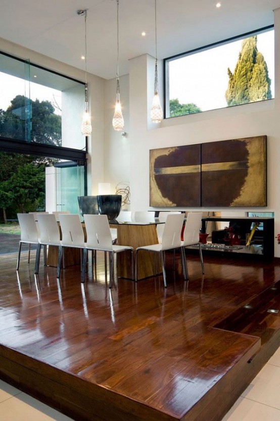 a polished and rich-stained wooden platform highlights the dining space and separates it fromt he rest of the layout