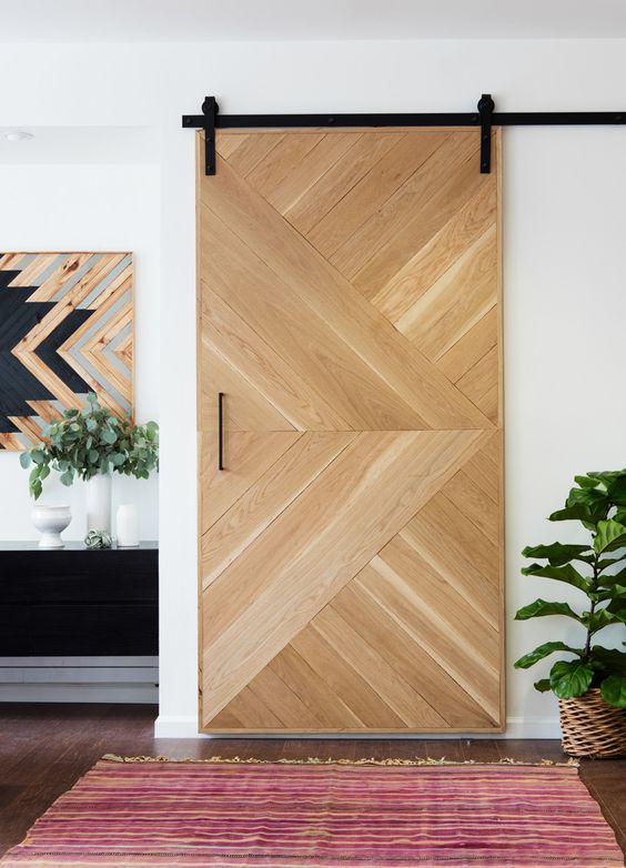 a geometric wooden sliding door adds a rustic yet modenr feel to the space
