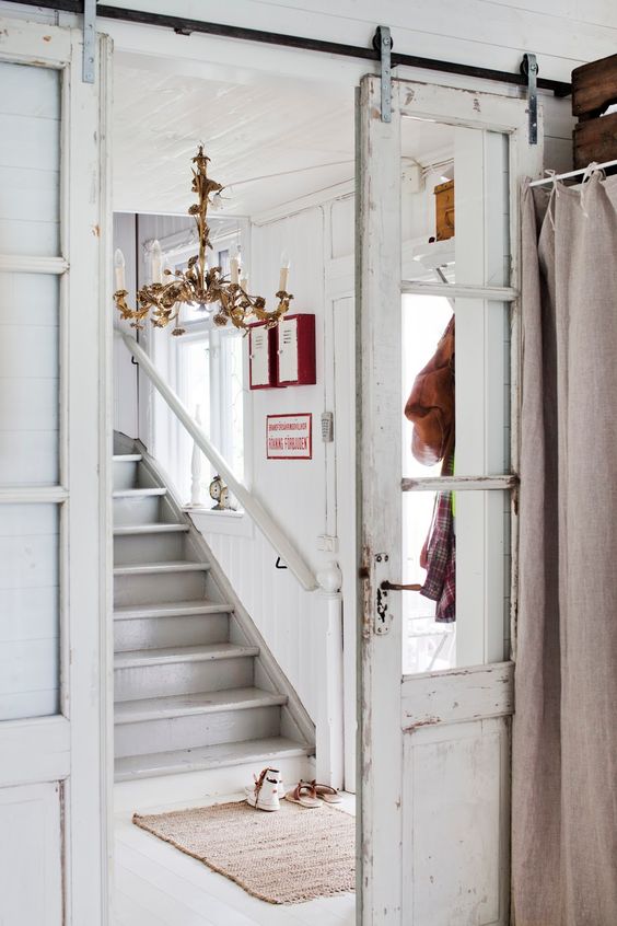a vintage whitewashed sliding door adds chic to the space gently separating the spaces