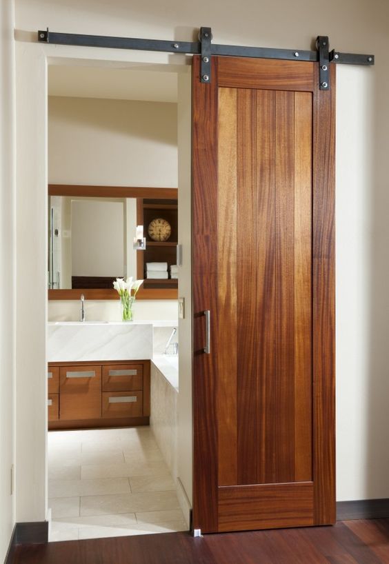 a wooden sliding door adds rustic chic to the space and matches the cabinets