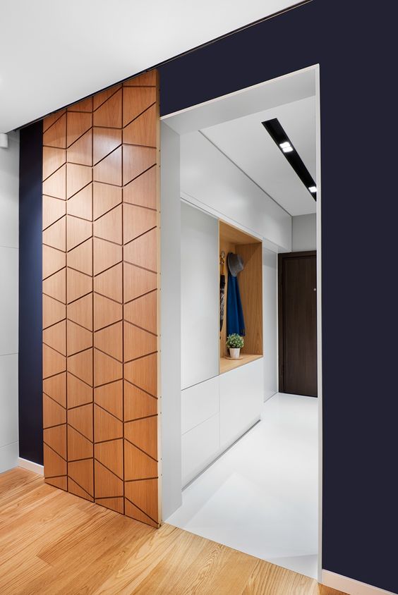 a modern plywood sliding door with a geometric pattern adds chic to the space