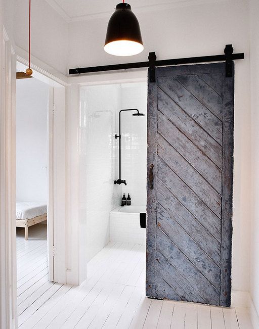 a rustic barn sliding door in grey contrasts the modern space and adds color