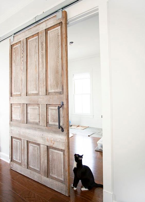 a vintage wooden sliding door with handles adds a refined touch to the space
