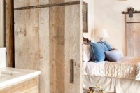 a rough wood sliding door for a rustic touch and cozy feel in the space