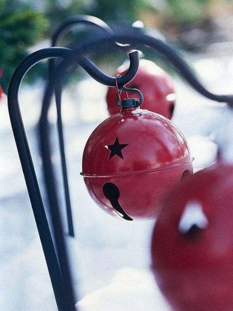hang oversized Christmas bells in red on holders to infuse your outdoor spaces with a Christmas feel