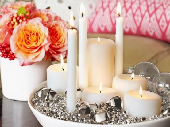 a bowl with silver bells or various sizes, sheer ornaments and candles of various shapes and sizes is a bold and glam Christmas centerpiece