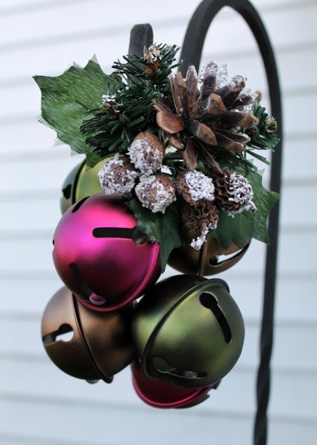 an outdoor Christmas decoration of pink, green and brown bells, snowy pinecones, foliage is pretty, bold and very modern