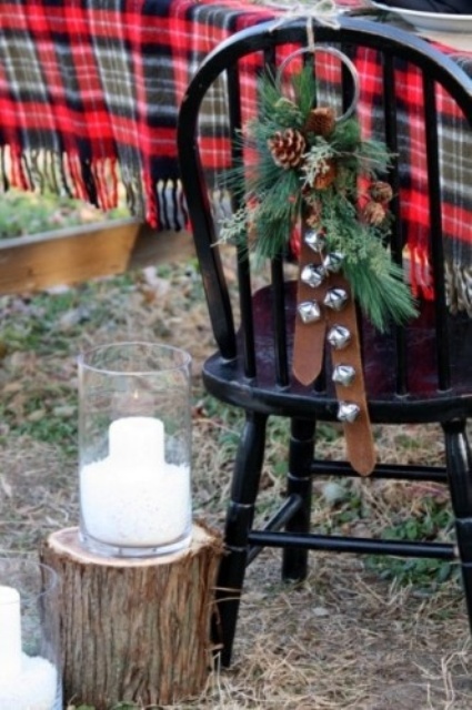 a lovely Christmas hanging of silver bells, leather belts, fir branches and pinecones is a lovely decoration to rock