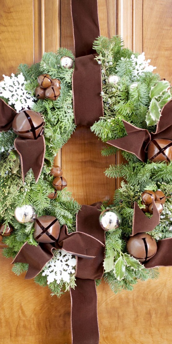 a chic fir wreath with bells, silver ornaments, white snowflakes and oversized brown bells and brown ribbon is a lovely and chic idea for the holidays